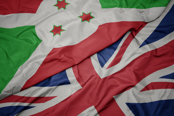 waving colorful flag of great britain and national flag of burundi.