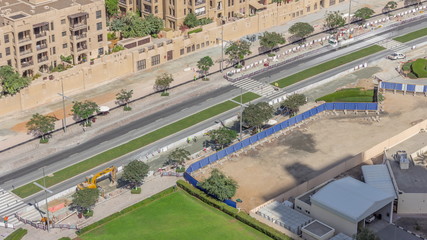 Excavator, truck and grader working at road construction site in Dubai downtown timelapse