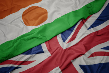 waving colorful flag of great britain and national flag of niger.