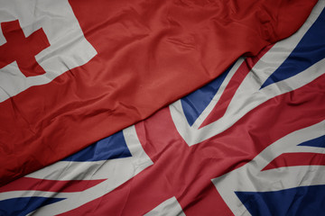 waving colorful flag of great britain and national flag of Tonga.