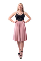 Candid laughing young beautiful blonde woman in pleated salmon skirt looking at camera. Full body isolated on white background. 