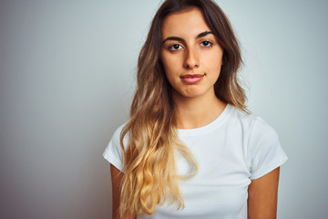 Fototapeta premium Young beautiful woman wearing t-shirt over white isolated background with a confident expression on smart face thinking serious