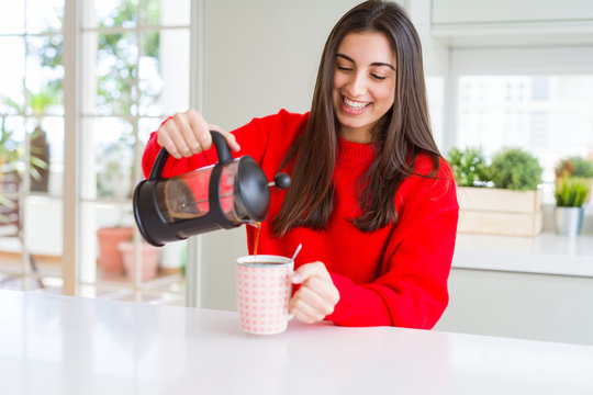Young beautiful woman making morning coffee smiling, preparing a cup of latte for breakfast