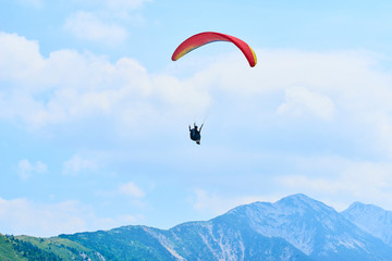 Paraglider flying over the Garda Lake (Lago di Garda or Lago Benaco), Panorama of the gorgeous Garda lake surrounded by mountains. Paragliding is very popular sport in Monte Baldo. Malcesine, Italy