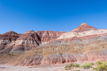 Landscape of red, orange, pink and white striped or banded hills at Paria Canyon in Grand Staircase Escalante National Monument