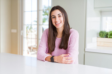 Beautiful young woman wearing pink sweater with a happy and cool smile on face. Lucky person.