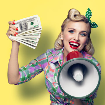 Woman with cash money and megaphone, dressed in pin up style, over yellow background