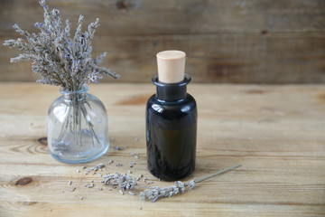 Close-up. Essential oil in a bottle and lavender herb on a wooden background Alternative medicine . Massage oil. Cosmetics care. Aromatherapy. Spa. With copy space for text.