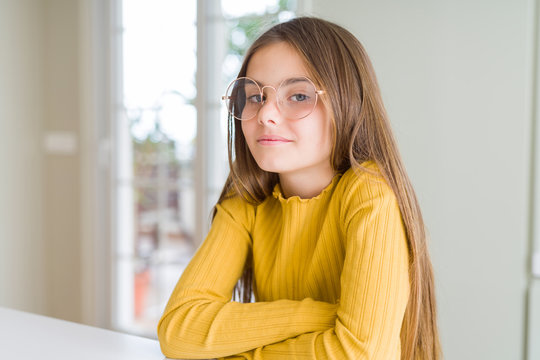 Beautiful young girl kid wearing glasses Relaxed with serious expression on face. Simple and natural with crossed arms