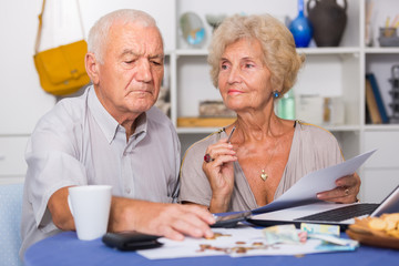 Serious senior couple counting bills