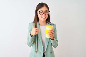 Young chinese woman wearing glasses drinking coffe over isolated white background happy with big smile doing ok sign, thumb up with fingers, excellent sign