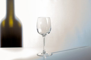 Empty glass. The shadow of the wine bottle