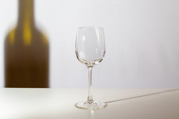 Empty glass. The shadow of the wine bottle