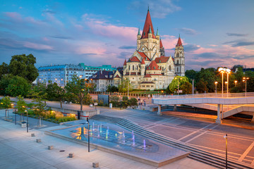 Wien, Österreich. Stadtbild der Wiener Hauptstadt Österreichs mit der Kirche St. Franziskus von Assisi während des schönen Sonnenuntergangs.