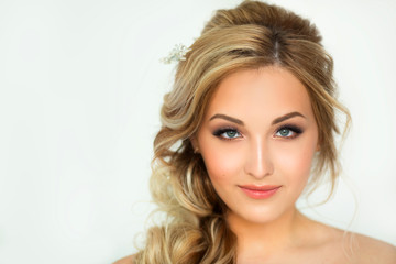 portrait of a beautiful young woman with makeup and hairstyle in a beautiful dress on a white background