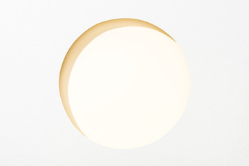 cut out round hole in white paper on light yellow background