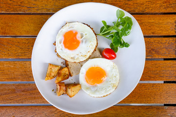 two fired eggs on white plate