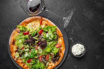 Tasty appetizing vegetarian pizza on dark background. Horizontal.