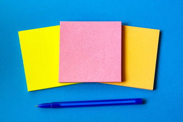 stickers for notes and pen lie on a blue background.