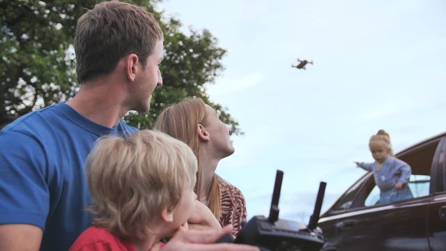 A friendly family launches a drone and controls it through the control panel.