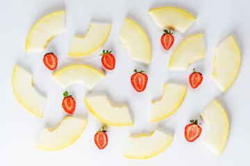 Melon slices and strawberry on a white background.