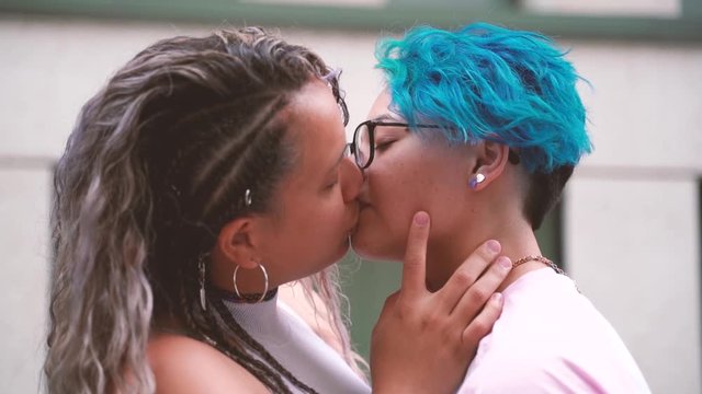 Teenager love.Gay young relationship. Blue short hair lesbian icon.Sweet and tender kiss between two women in love. Public shown of affection. Free love to all sexual orientation. 