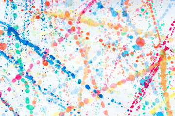 multicolored watercolor blots on white paper background
