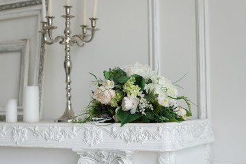Artificial flowers on a white fireplace