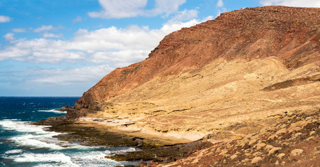 Scenic rocky beach coastline at the base of Mount Bocinegro near El Medano town, Tenerife, Spain