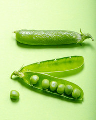 Fresh green peas on green background