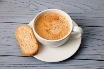 Cup of coffee with cookies on a wooden table