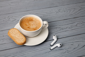 wireless headphones and Cup of coffee with coockies