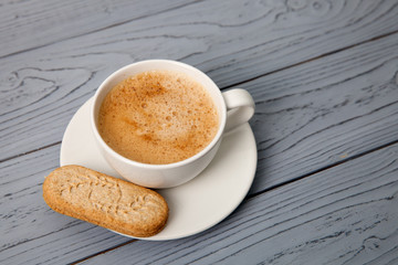 A cup of coffee with a cookie