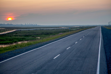 Fototapeta premium Beautiful sunset on the background of an asphalt road