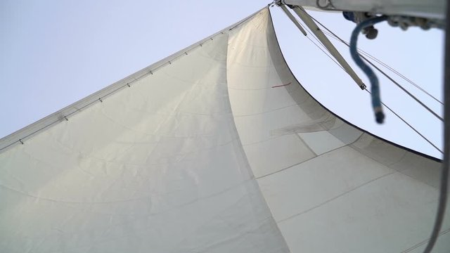 Mast with a white sail on a yacht in the Black Sea