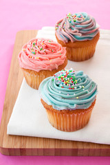 Pink and blue cupcakes on a pink background