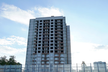Fototapeta premium A multi-storey building is under construction. Skeleton of a building without windows. Real estate under construction for housing