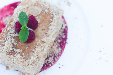 Restaurant with Napoleon Dessert or Mille-Feuilles owhite plate Background. Exquisite Serving Rectangular Piece of Millefeuille, With raspberry