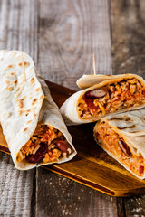 Burritos on cutting board on wooden table