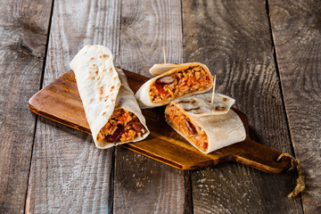 Burritos on cutting board on wooden table