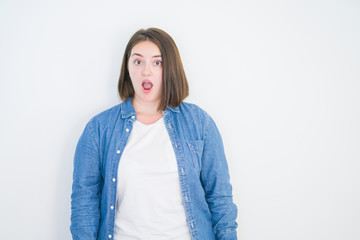 Obraz premium Young beautiful plus size woman over white isolated background afraid and shocked with surprise expression, fear and excited face.
