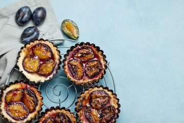 Baking with plums on a blue concrete background. Confectionery products