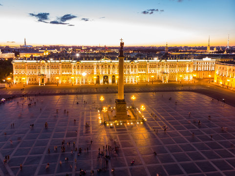 Aerial front view at the Winter Palace building in white nights, exterior Palace Square and Aleksandr Column at summer. Top view from drone. Saint-Petersburg, Russia