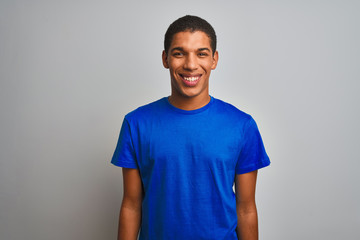 Young handsome arab man wearing blue t-shirt standing over isolated white background with a happy and cool smile on face. Lucky person.