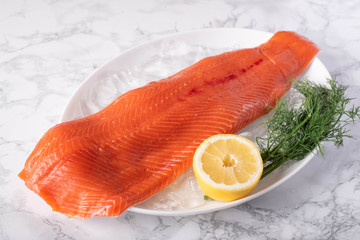 whole raw salmon fillet on marble background