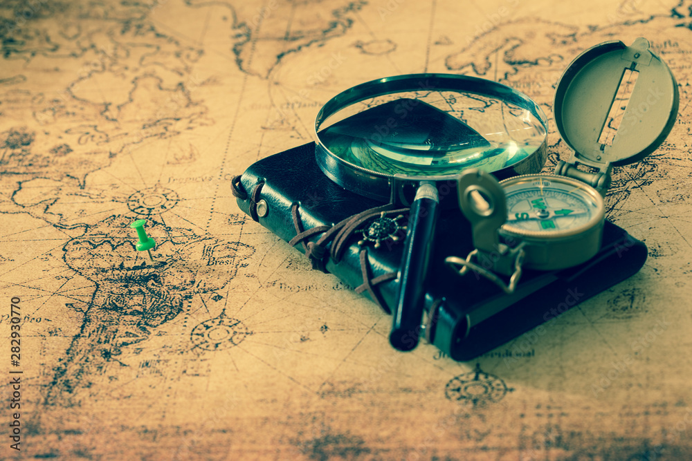 Aufkleber old map with compass, notebook and magnifying glass. the concept of searching for interesting places