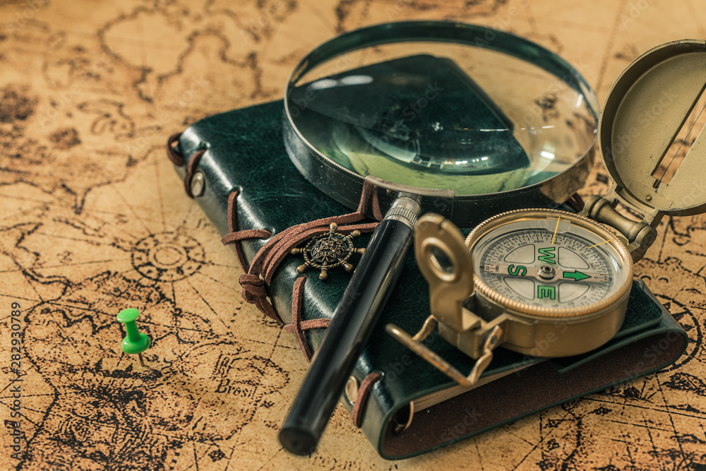 Aufkleber old map with compass, notebook and magnifying glass.  The concept of searching for interesting places or treasures around the world.