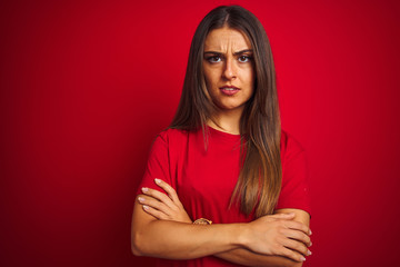 Young beautiful woman wearing t-shirt standing over isolated red background skeptic and nervous,...