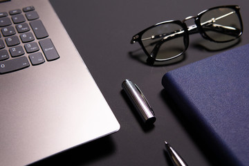 Notebook, laptop, glasses and pen on the table. Concept of business or study.