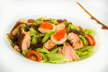 Healthy lunch salad with baked salmon fish, fresh radish, lettuce and lime